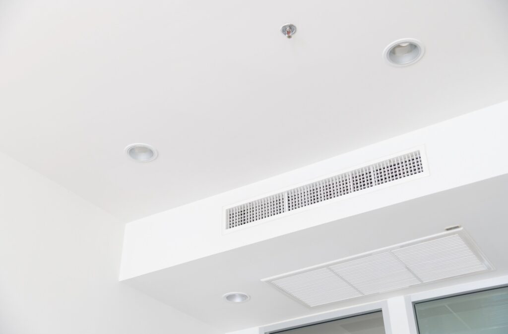 Ceiling with ventilation grille and recessed lighting fixtures, illustrating HVAC airflow solutions for residential comfort in Cookeville.